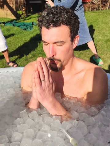 Enis Bedda in an ice bath, hands together, eyes closed