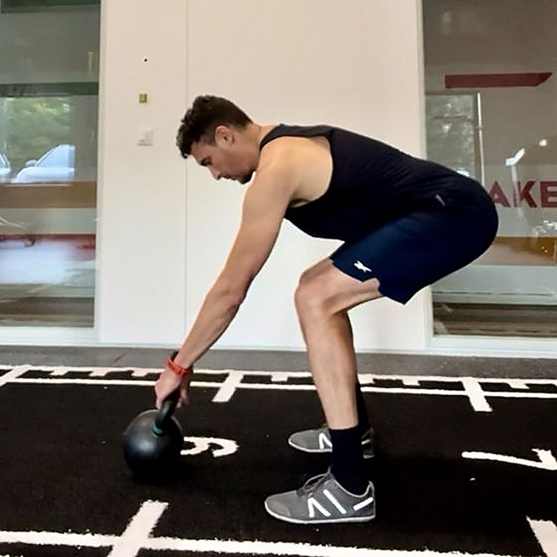 Enis Bedda setting up a kettlebell swing in the studio